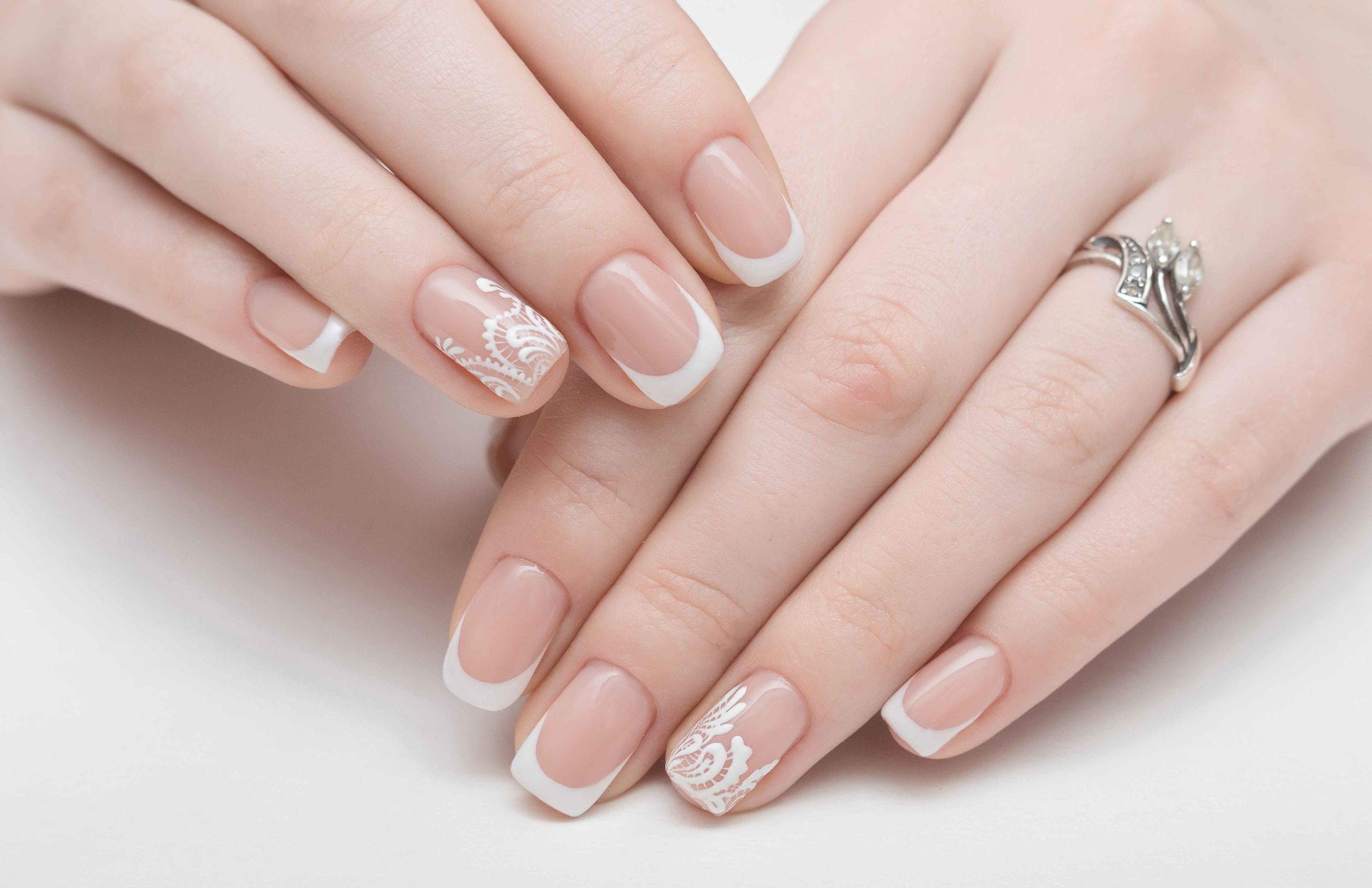 Manos entrelazadas con uñas pintadas y esculpidas