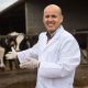 Veterinario delante de establo de vacas