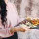 Chica portando bandeja con comidas