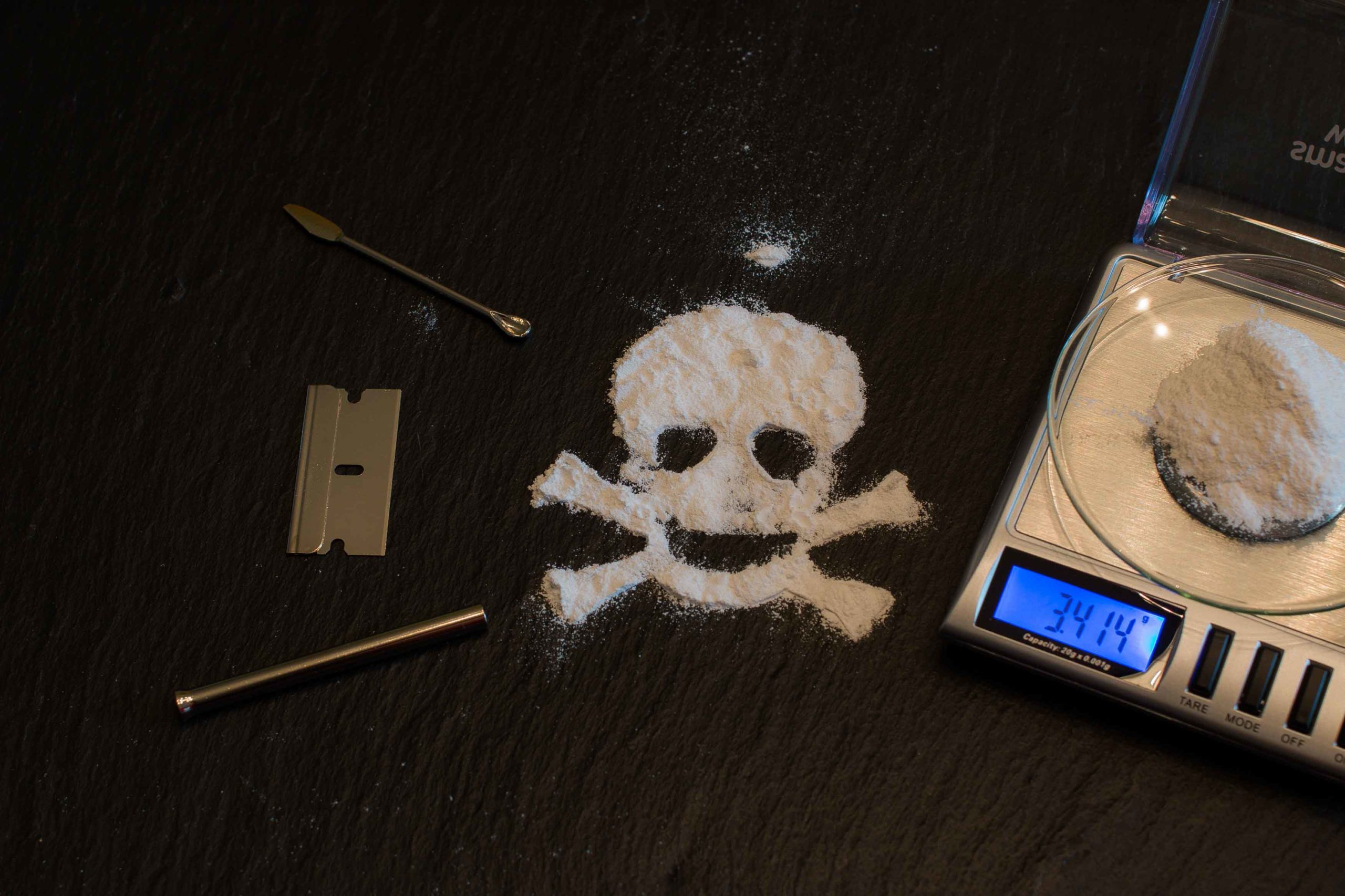 Báscula con coaína y cocaína dibujando una calavera