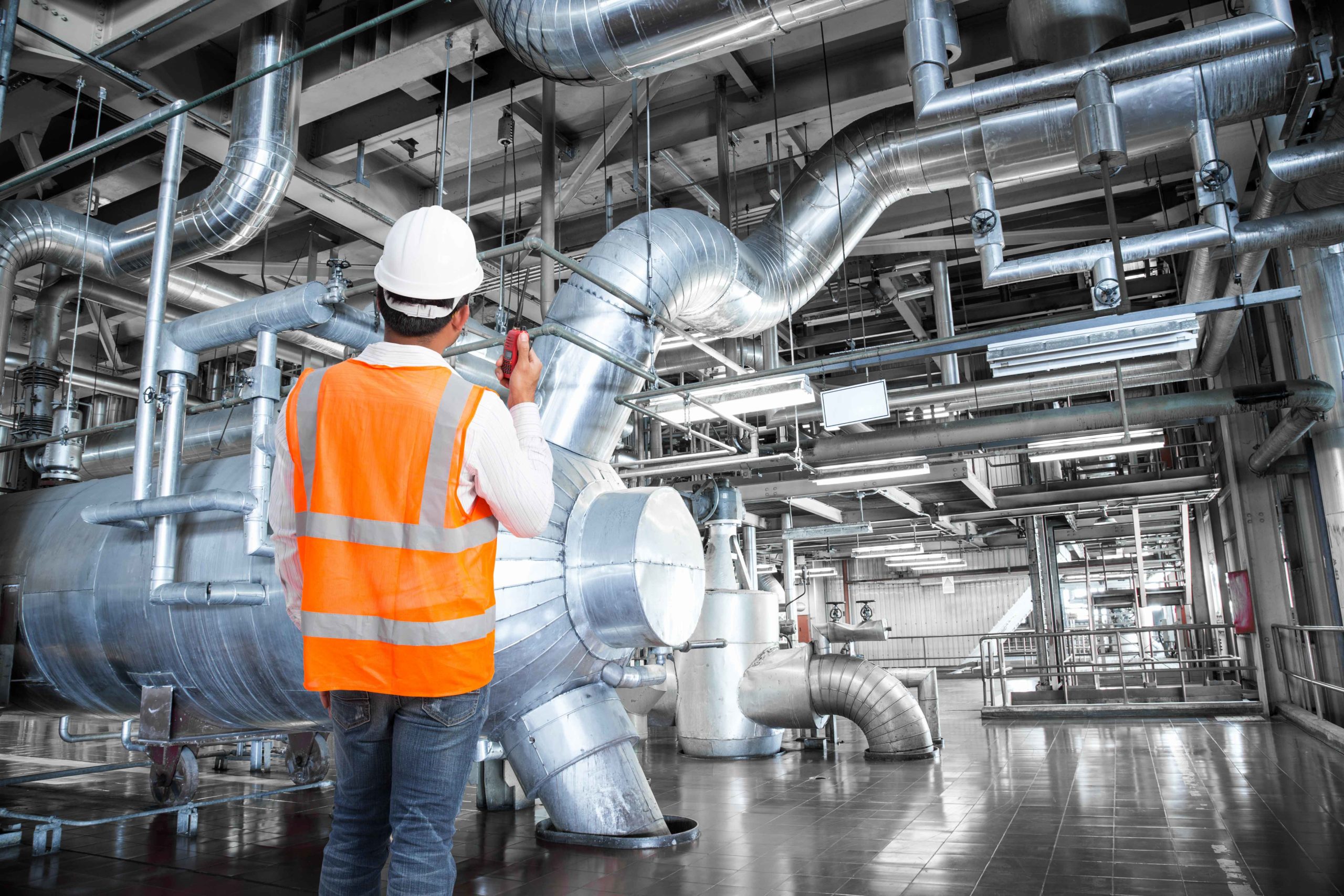 Técnico mirando tuberías industriales