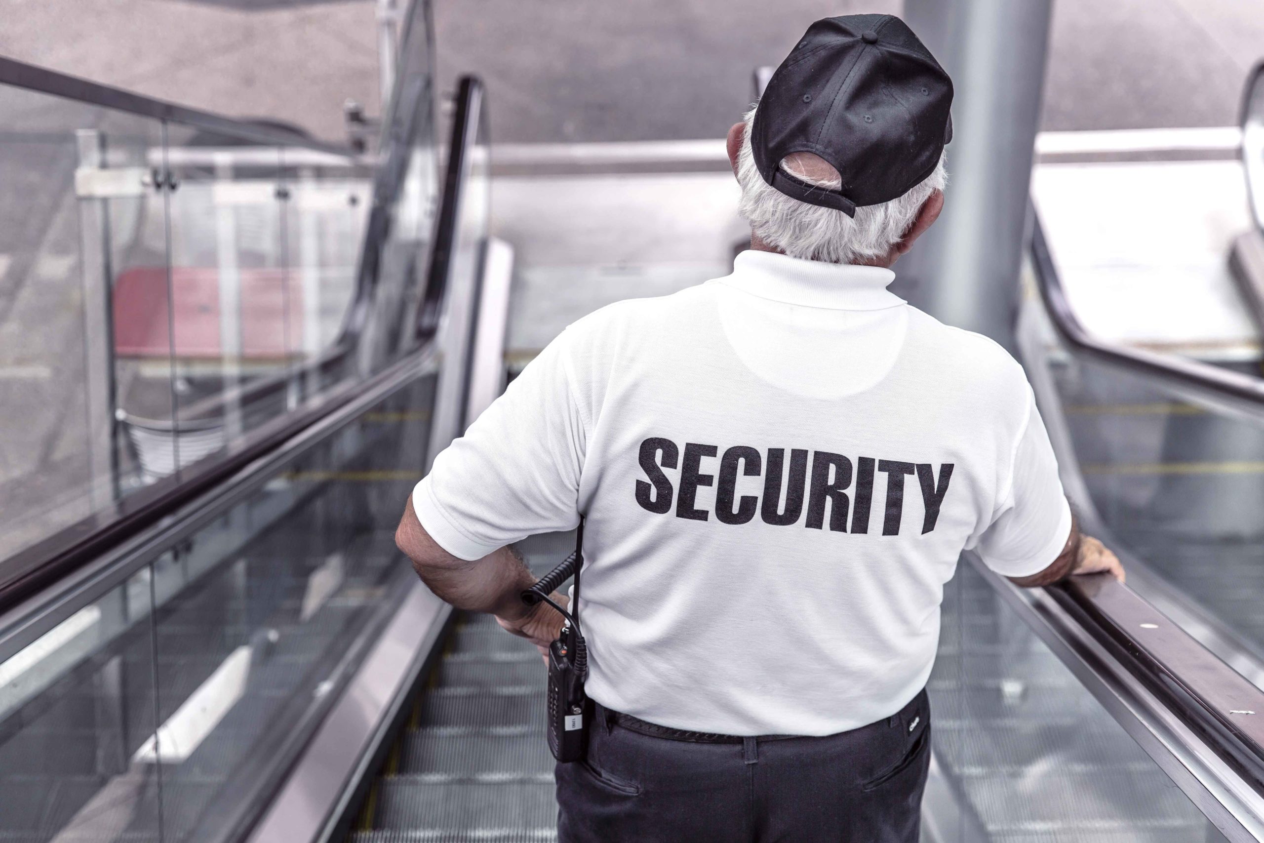 Guardia de seguridad bajando por escaleras mecánicas