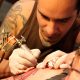 tatuador realizando una obra en un brazo